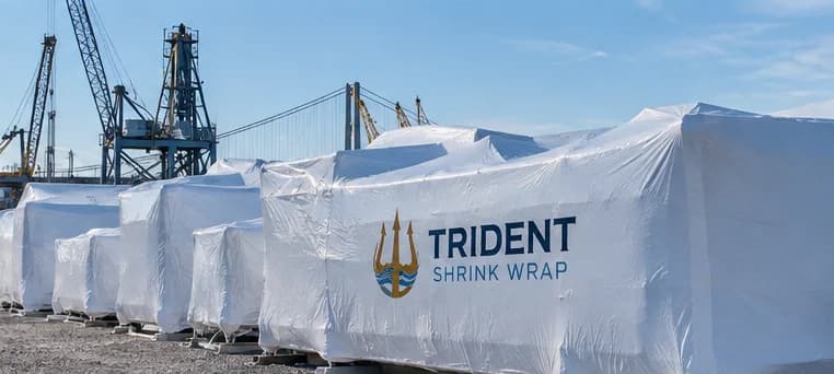 A row of palletised industrial loads shrink wrapped in white film at a port